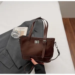 Détail du sac cabas en cuir PU marron foncé avec fermoir rotatif argenté et double poignée