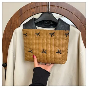 Detailansicht der senfgelben gesteppten Handtasche mit eleganten schwarzen Schleifenakzenten