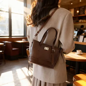 Sac seau vintage marron foncé avec fermoir argenté porté par un mannequin en café