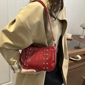 Glossy red faux leather underarm bag with silver rivets and thin shoulder strap