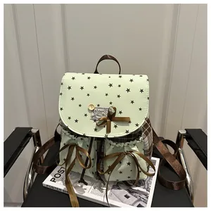 Detail view of mint green star print backpack with brown plaid panels and bow accent