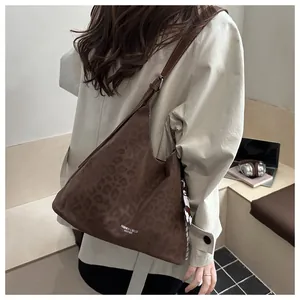 Détail du sac vintage imprimé léopard avec surpiqûres blanches et texture cuir