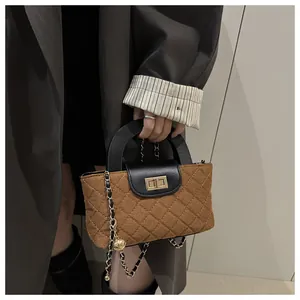 Close-up of quilted fabric texture with gold metal lock and leather chain strap