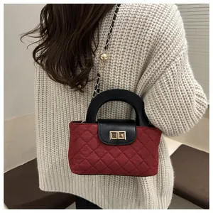 On-body view of red quilted shoulder bag with chain strap and gold hardware