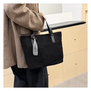 Dettaglio della borsa a secchiello in peluche nero con morbida pelliccia e ciondolo in pelle