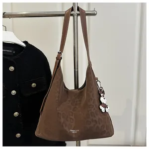 Détail du sac hobo léopard avec poignée lisse et pendentif en forme d'ours mignon
