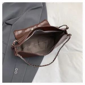 Top view of large brown shoulder bag showing spacious interior and chain strap detail