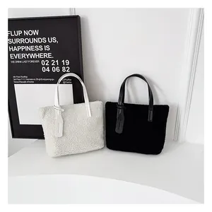Dettaglio di borse tote in morbido sherpa nero e beige con manici in pelle liscia