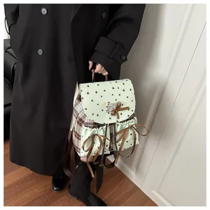 Detail of vintage plaid backpack featuring mint green star pattern and brown ribbon bows