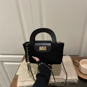 Quilted black leather handbag with gold twist lock and metal chain strap for women