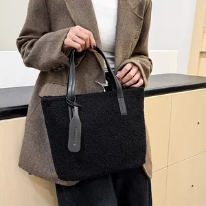 Elegante borsa a secchiello in peluche nera con manici in pelle e pendaglio