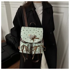 Detail of vintage mint green backpack with star patterns and brown ribbon bows