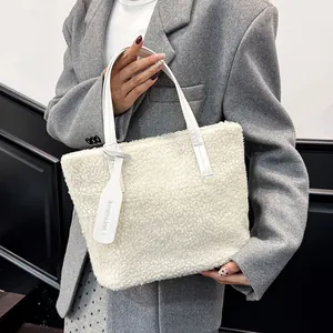 Borsa a secchiello in peluche bianco con manici in pelle e targhetta per l'autunno inverno