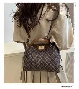 Détail du sac à bandoulière marron à motif monogramme et finitions dorées
