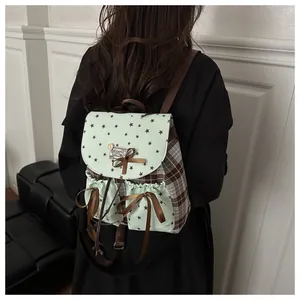 Detail of vintage mint green backpack with star patterns and brown plaid side panels