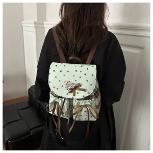 Detail of mint green and brown plaid mini backpack with satin bow and star prints