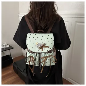 Detail view of the green vintage backpack featuring black star patterns and lace bow accents