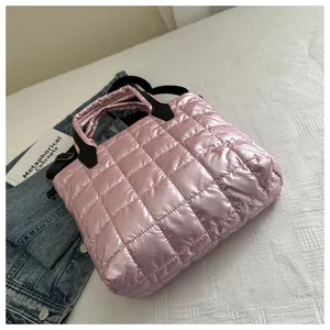 Détail d'un sac cabas rose matelassé avec fini métallisé et bandoulière noire