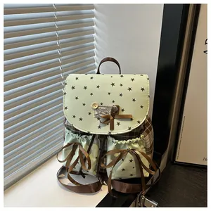 Detail of vintage school-style backpack with lace bow, star print, and plaid fabric textures