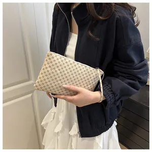 Dettaglio del cinturino da polso e della cerniera di questa elegante borsa a mano a motivi
