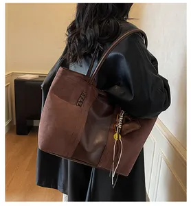 Dettaglio della borsa tote marrone scuro con patchwork scamosciato e trama laterale