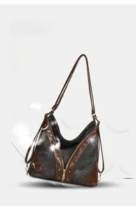 Macro shot of retro tote bag showing grey canvas texture, brown leather trim, and feathers
