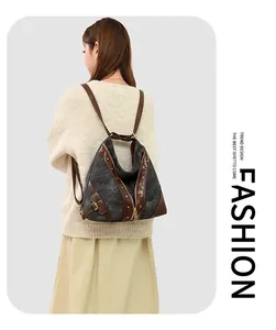 Detailed back view of vintage canvas backpack with rivets and leather straps on model