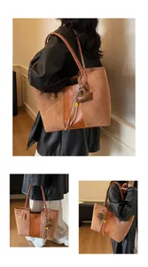 Dettaglio della borsa tote in pelle scamosciata marrone con dettagli intrecciati e nappe
