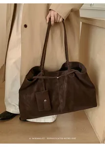 Detail of deep brown retro tote bag with minimalist strap and matching mini pouch