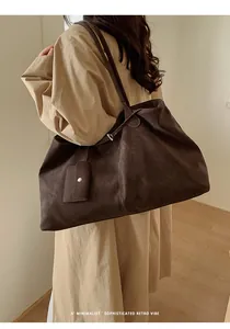 Detail of a large vintage brown faux suede tote bag with minimalist shoulder straps