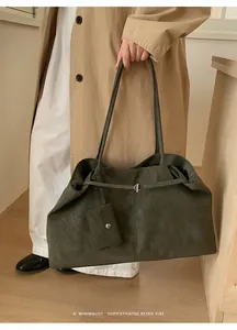 Detail of a large olive green tote bag showing matte texture and a matching mini pouch