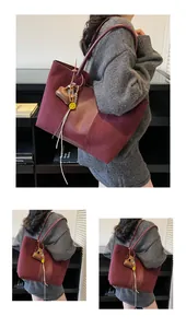 Dettaglio della borsa tote bordeaux scuro con ciondolo a cuore e charm a forma di smiley