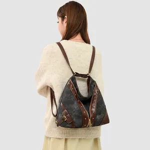 Retro canvas and leather patchwork backpack with gold studs shown on model back