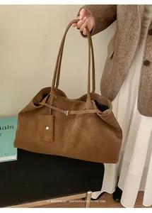 Close-up of a vintage brown tote bag in matte suede with a detachable mini card pouch