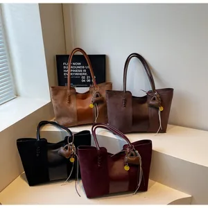 Dettaglio di quattro borse tote in pelle scamosciata patchwork con ciondoli a cuore