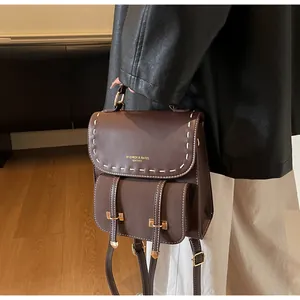 Detail eines braunen Vintage-Lederrucksacks mit Kontrastnähten und Metallschnallen