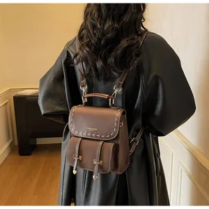 Details des braunen Vintage-Lederrucksacks mit Kontrastnähten und goldener Schrift