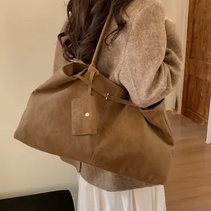Retro brown suede tote bag with small pouch shown on model in a cozy home setting