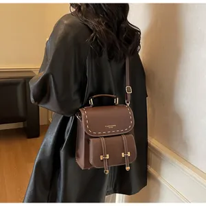 Details des braunen Vintage-Lederrucksacks mit weißen Nähten und goldener Schnalle