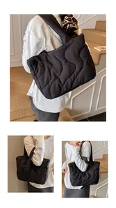 Detail view of black quilted tote bag with wave stitching and soft nylon texture