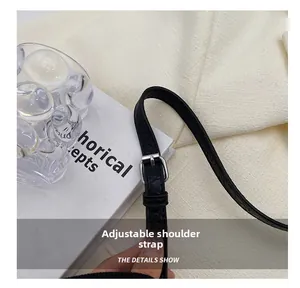 Detail eines verstellbaren schwarzen Schultergurts aus Leder mit Silberschnalle