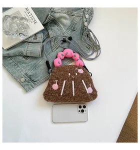 Dettaglio mini borsa in peluche marrone con ricamo ciliegia e manico rosa a volant