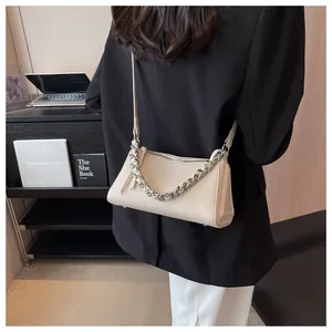 Detailansicht der cremeweißen Ledertasche mit Litschi-Maserung und silberner Kette