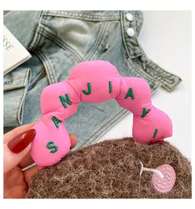 Dettaglio borsa di peluche marrone con manico rosa imbottito e ricamo SANJIAYI