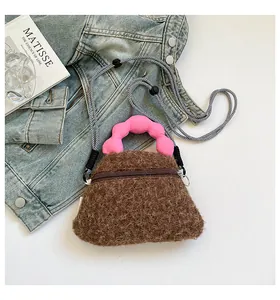 Dettaglio mini borsa in peluche con manico a nuvola rosa e tracolla intrecciata