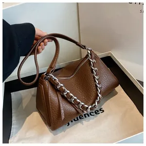 Detail der braunen Kissen-Tasche aus Litschileder mit klobiger silberner Kette