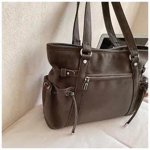 Primer plano del bolso de cuero vintage marrón oscuro con cordón lateral y cremallera