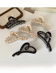 Détails de pinces à cheveux en forme de cœur avec motifs floraux sur un plateau en bois