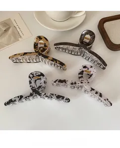 Vue détaillée de quatre grandes pinces à cheveux en acrylique à motif marbre et léopard