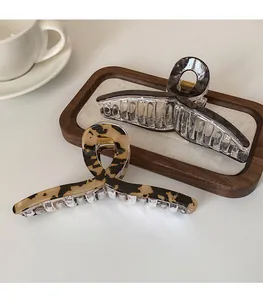 Détail de pinces à cheveux à motif marbre et léopard sur un plateau élégant